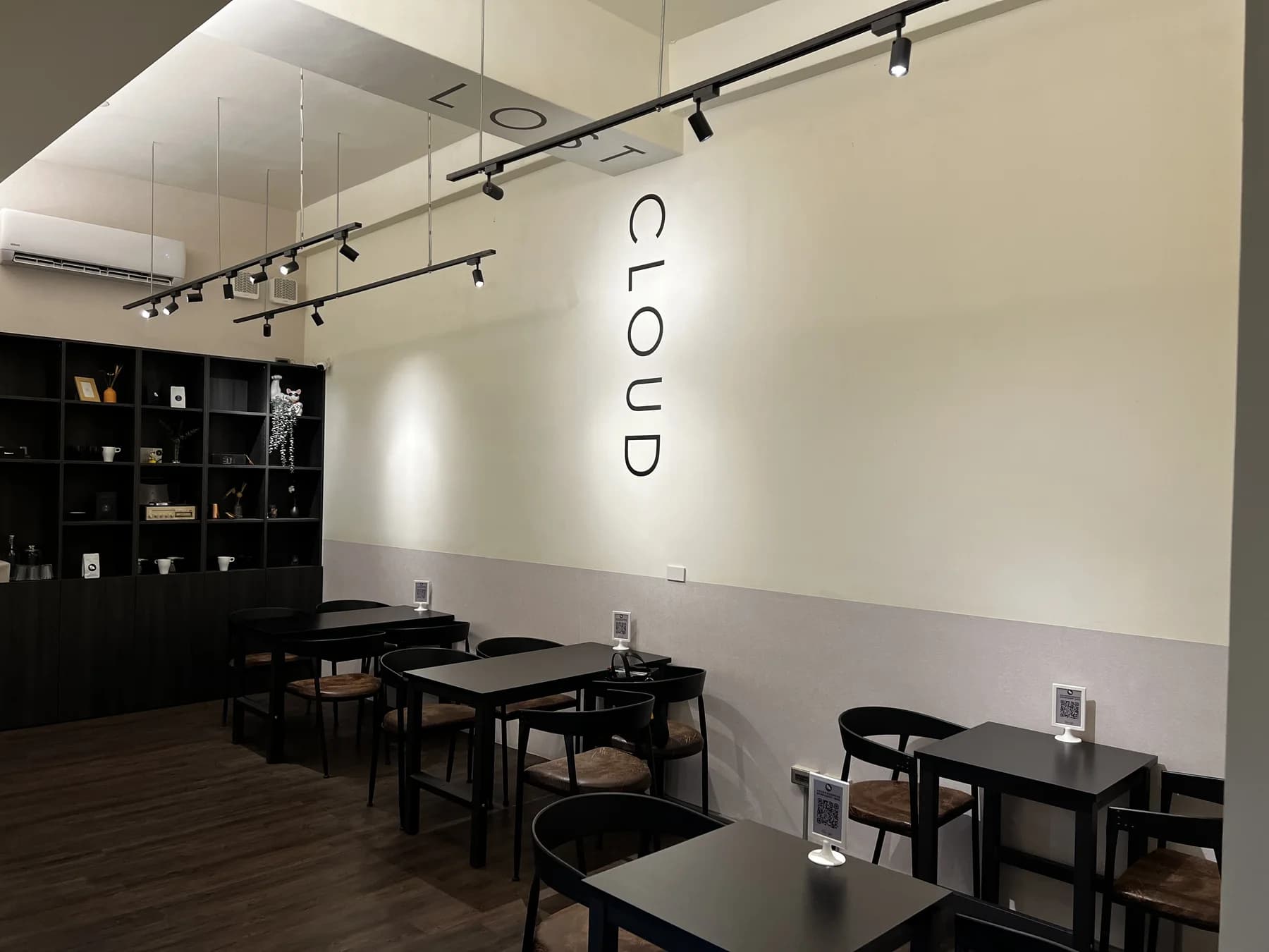 湮云咖啡地下室座位區,黑色桌椅、展示櫃與 CLOUD 字樣牆面