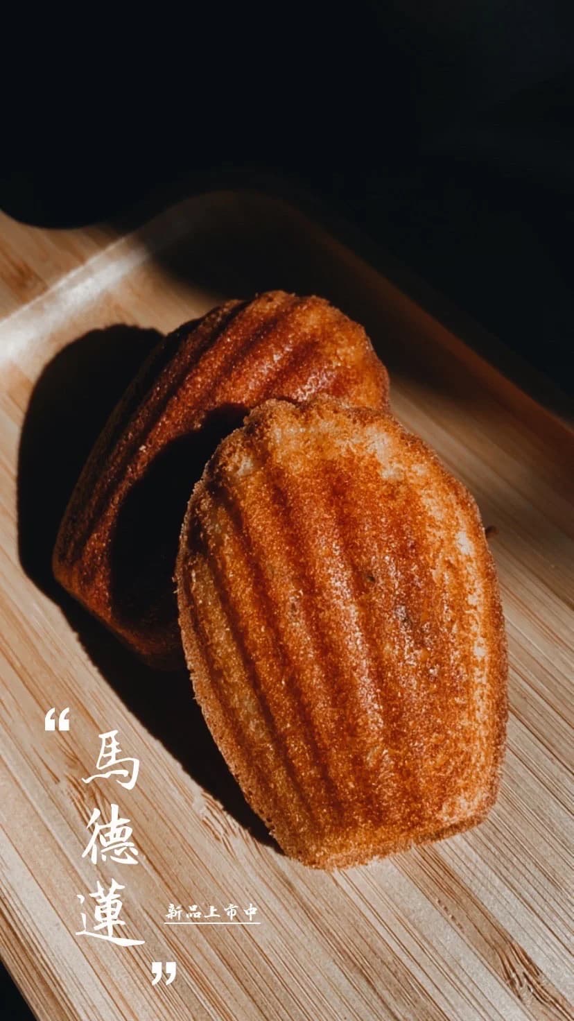 湮云咖啡的常溫甜點瑪德蓮,木盤上的貝殼形小蛋糕